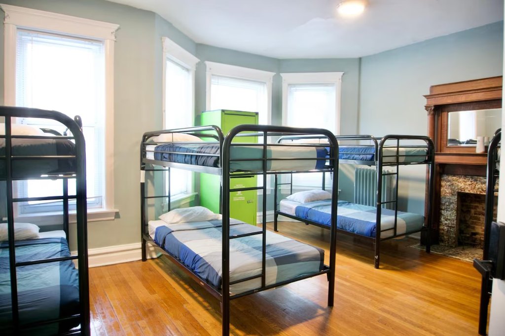 A bright bunk-bed dorm with a bay window